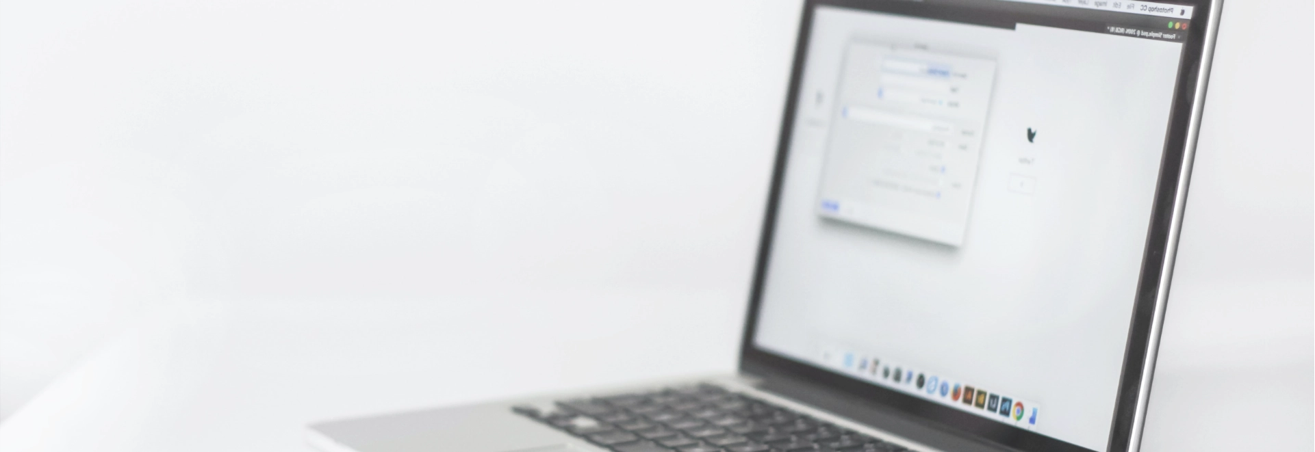 Blurred image showing an opened laptop lying on a table.